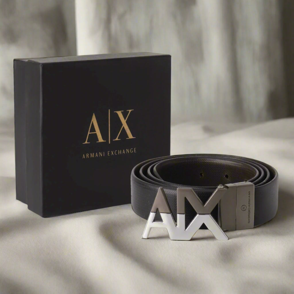Black Armani Exchange belt with silver buckle next to a branded box on a white background