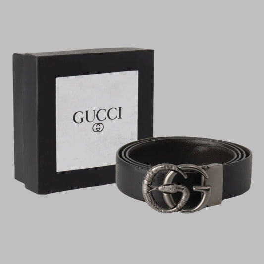 Black Gucci belt with silver buckle next to a black Gucci box on a white background